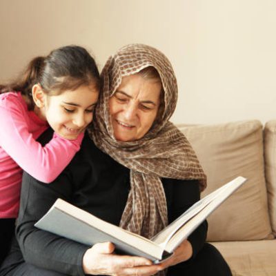 Grandmother reading a book with grand daughter